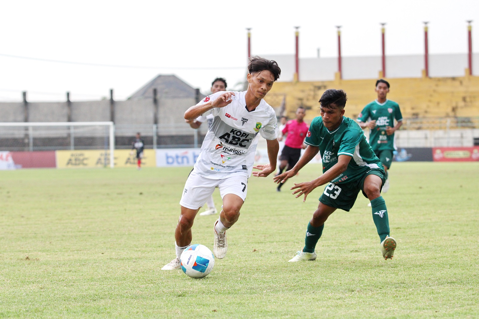 MENYERANG: Pemain Perssu MC Rifki Althafian (putih) mendapat gangguan dari pemain CMM saat bertanding di Liga 4 Jatim di SGB Minggu (5/1). (VIVIN AGUSTIN HARTONO/JPRM)