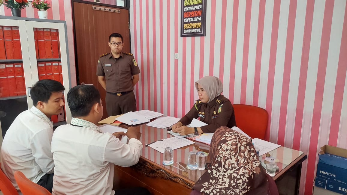 DIPERIKSA: Jaksa Annisa Novita Sari memeriksa dokumen di hadapan pegawai Pegadaian Pamekasan, Senin (30/12/2024). (ISTIMEWA)