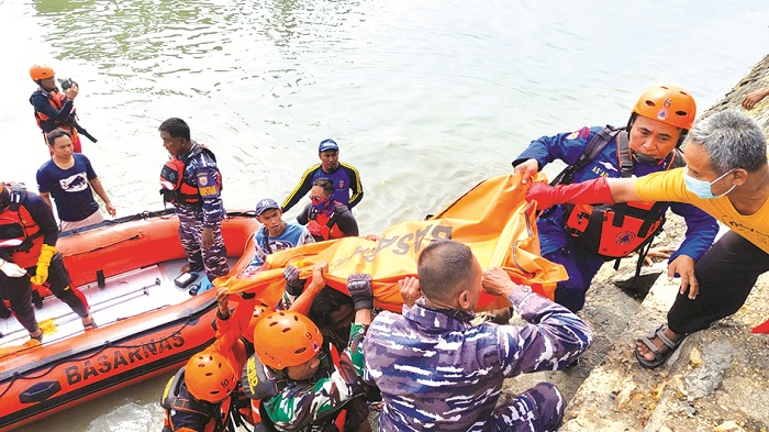 BERJIBAKU: Petugas mengevakuasi jenazah Darwin di Pelabuhan Branta, Desa Branta Pesisir, Kecamatan Tlanakan, Pamekasan, Senin (6/1). (POLRES PAMEKASAN UNTUK JPRM)