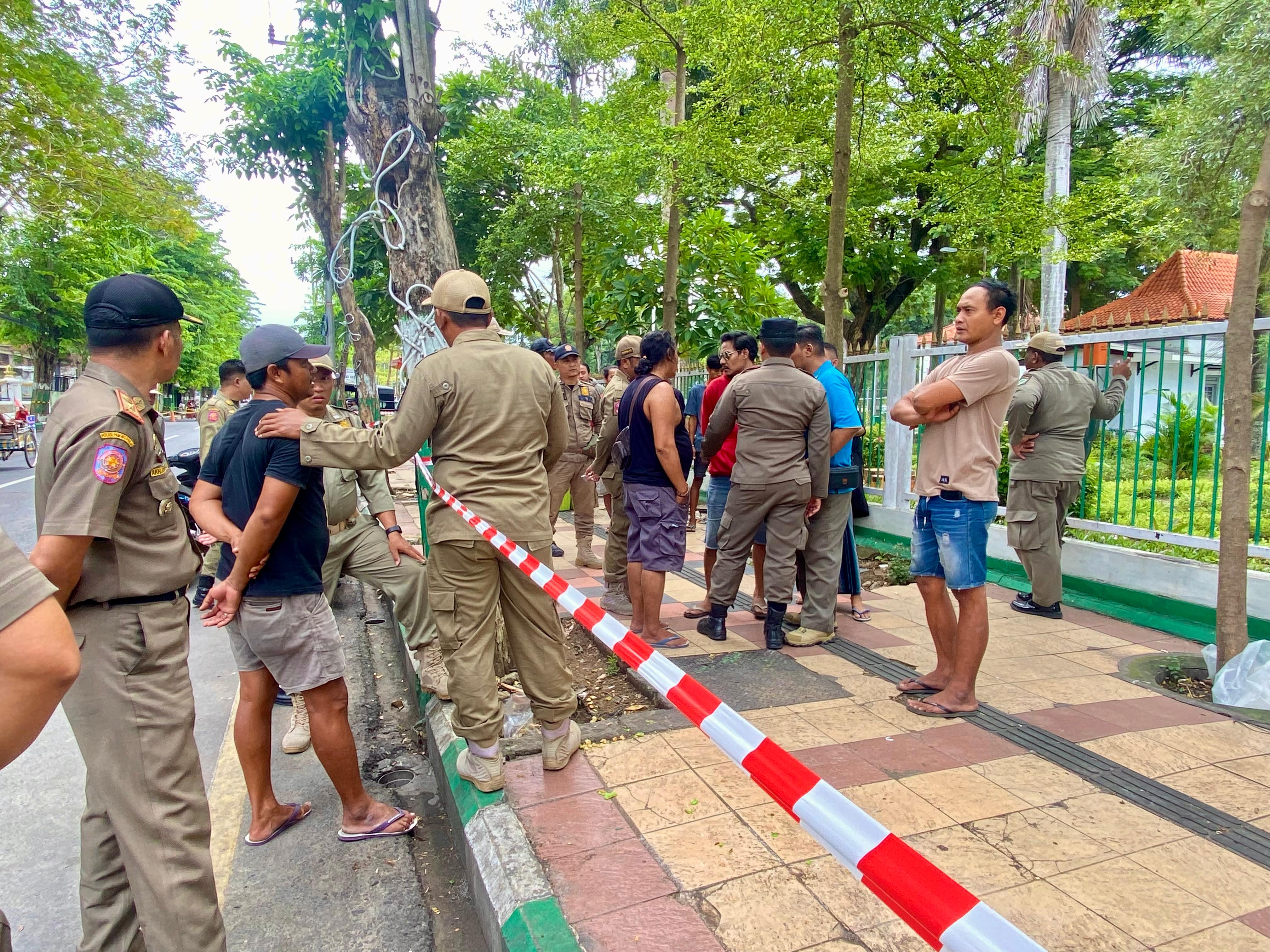 BERSITEGANG: Petugas Satpol PP dan Damkar Pamekasan berusaha menertibkan PKL di sekitar Monumen Arek Lancor, Selasa (7/1). (MOH. IQBAL AFGANI/JPRM)