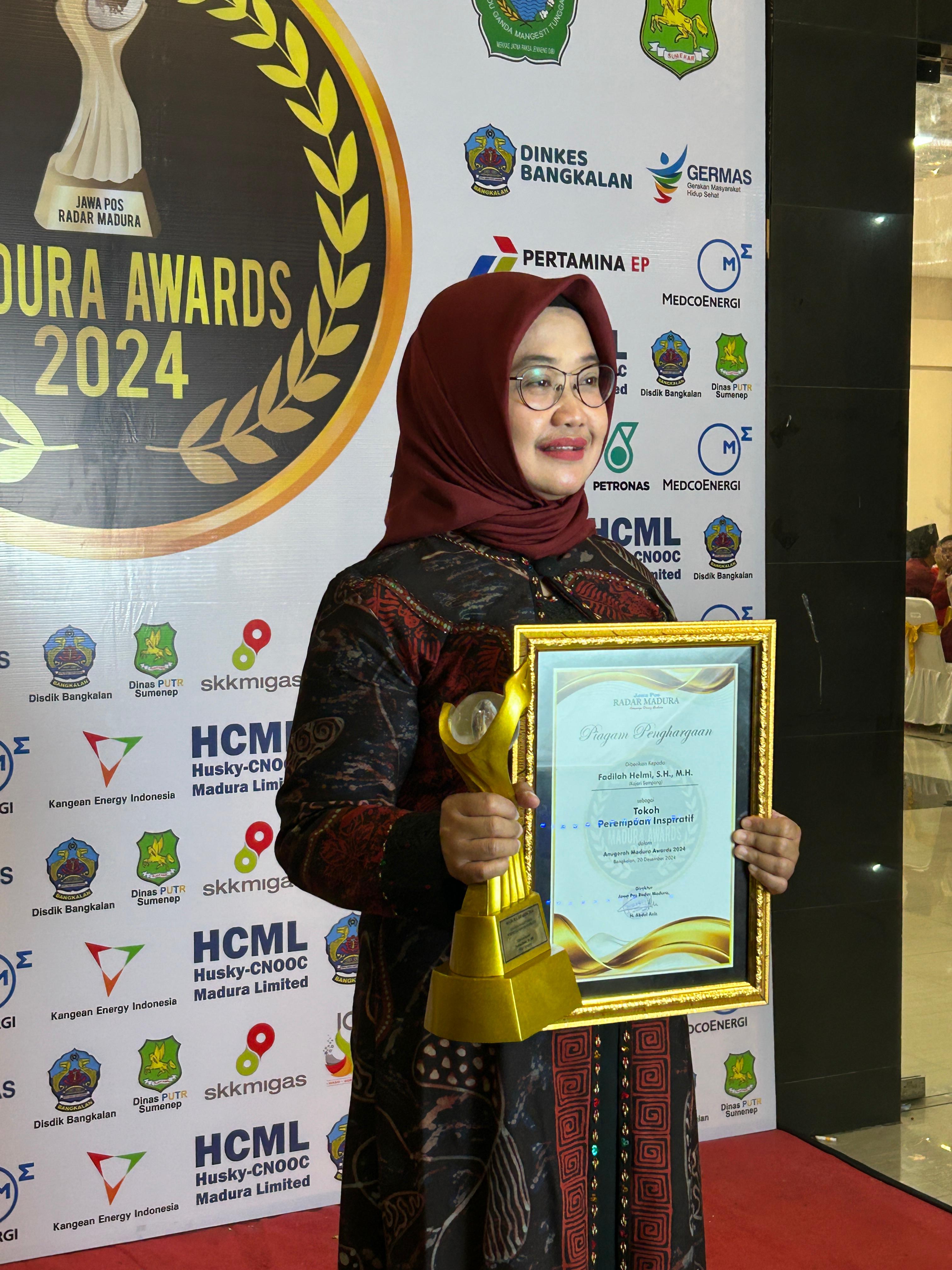 PERMEPUAN HEBAT: Kajari Sampang Fadilah Helmi menunjukkan piagam dan trofi Perempuan Inspiratif Madura Awards 2024 di Sentra IKM Bangkalan, Jumat (20/12). (ERWIN/JPRM)