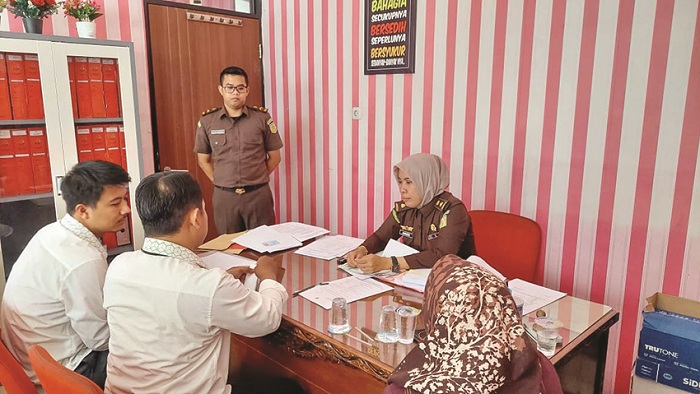 SERIUS: Jaksa Annisa Novita Sari memeriksa dokumen di hadapan pegawai Pegadaian Pamekasan, Senin (30/12/2024). (DOK JPRM)