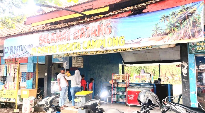 OBJEK WISATA: Beberapa pengunjung berada sekitar loket masuk Pantai Wisata Camplong, Sabtu (28/12/2024). (JUNAIDI PONDIYANTO/JPRM)
