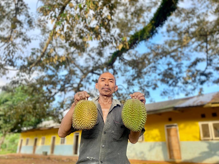 PALING LAKU: Busirah menunjukkan dua buah durian kasur, Jumat (10/1). (MOH. IQBAL AFGANI/JPRM)