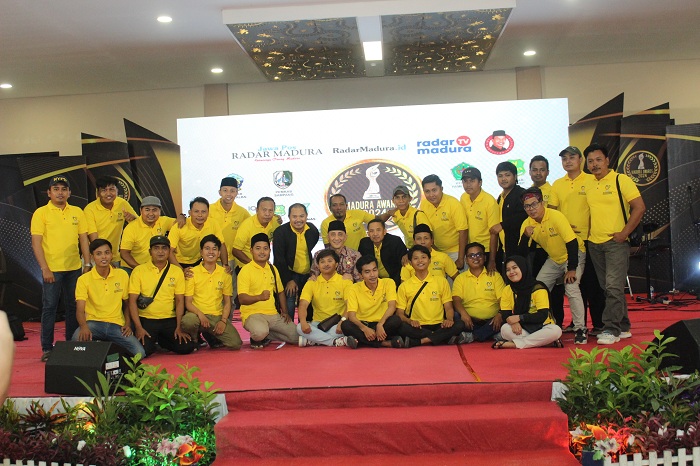 KOMPAK: Ketua SLRT Dinsos Bangkalan Mahmudi Ibnu Khotib dan anggota berfoto bersama Pj Bupati Arief M. Edie di panggung malam anugerah Madura Awards 2024 di Sentra IKM Bangkalan, Jumat (20/12/2024)