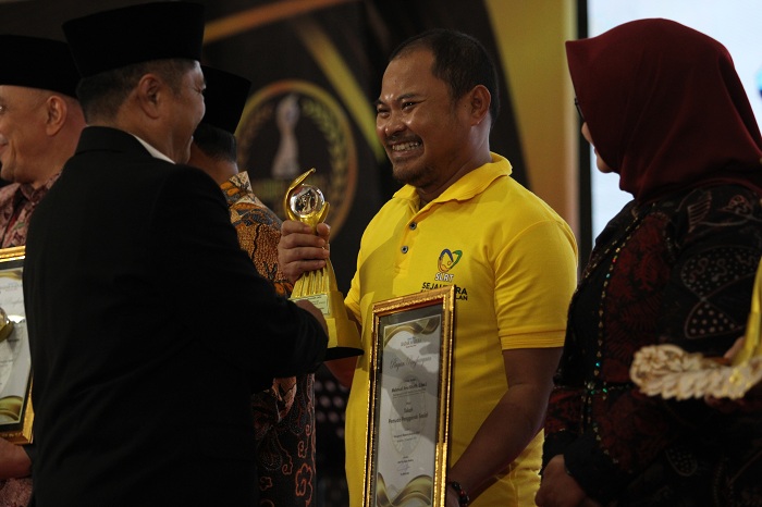APRESIASI: Direktur PT Madura Intermedia Pers Abdul Aziz memberikan trofi dan piagam penghargaan tokoh penggerak sosial dalam Madura Awards 2024 kepada Ketua SLRT Dinsos Bangkalan Mahmudi Ibnu Khotib.