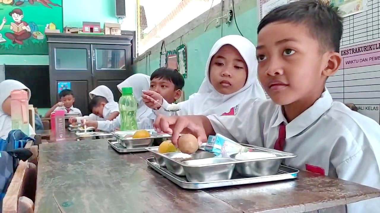PEMENUHAN GIZI: Sejumlah siswa menikmati makan bergizi gratis di SDN Pandian 1, Kecamatan Kota Sumenep, Senin (13/1). (MOH. LATIF/JPRM)