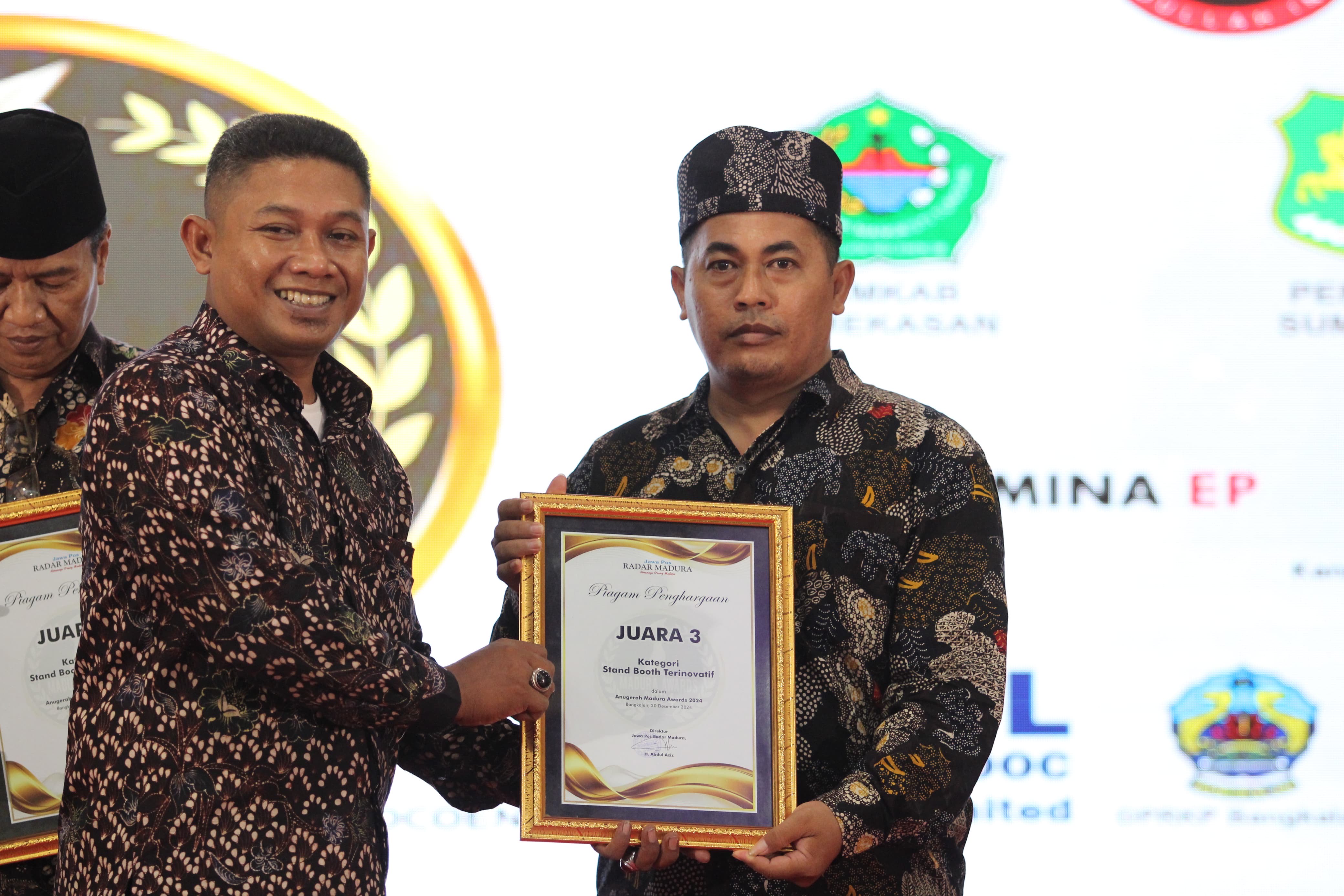 PRESTASI: Ketua DP Bangkalan Abdullah menyerahkan piagam penghargaan juara 3 stand booth terfavorit kepada Korwil Bidang Pendidikan Kecamatan Blega Munawir pada Madura Awards 2024 di Gedung Sentra IKM