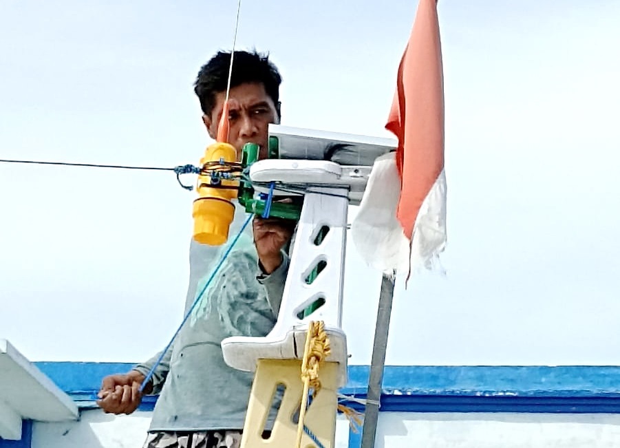 LINDUNGI NELAYAN: Seorang nelayan Pulau/Kecamatan Sapeken sedang memasang automatic identification system (AIS) dari program SiKapal di kapalnya pada 2023 lalu. (PROKOPIM SUMENEP UNTUK JPRM)