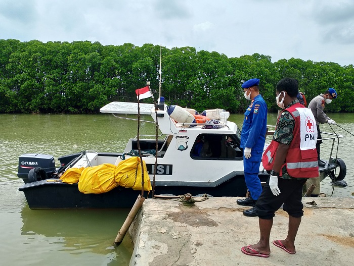 TEWAS: Petugas Satpolrairud Polres Sampang dan PMI Sampang hendak mengevakuasi mayat dari kapal di sungai Kelurahan Banyuanyar, Kecamatan Kota Sampang, Kamis (16/1). (UBAIDILLAHIR RA&rsquo;IE/JPRM)
