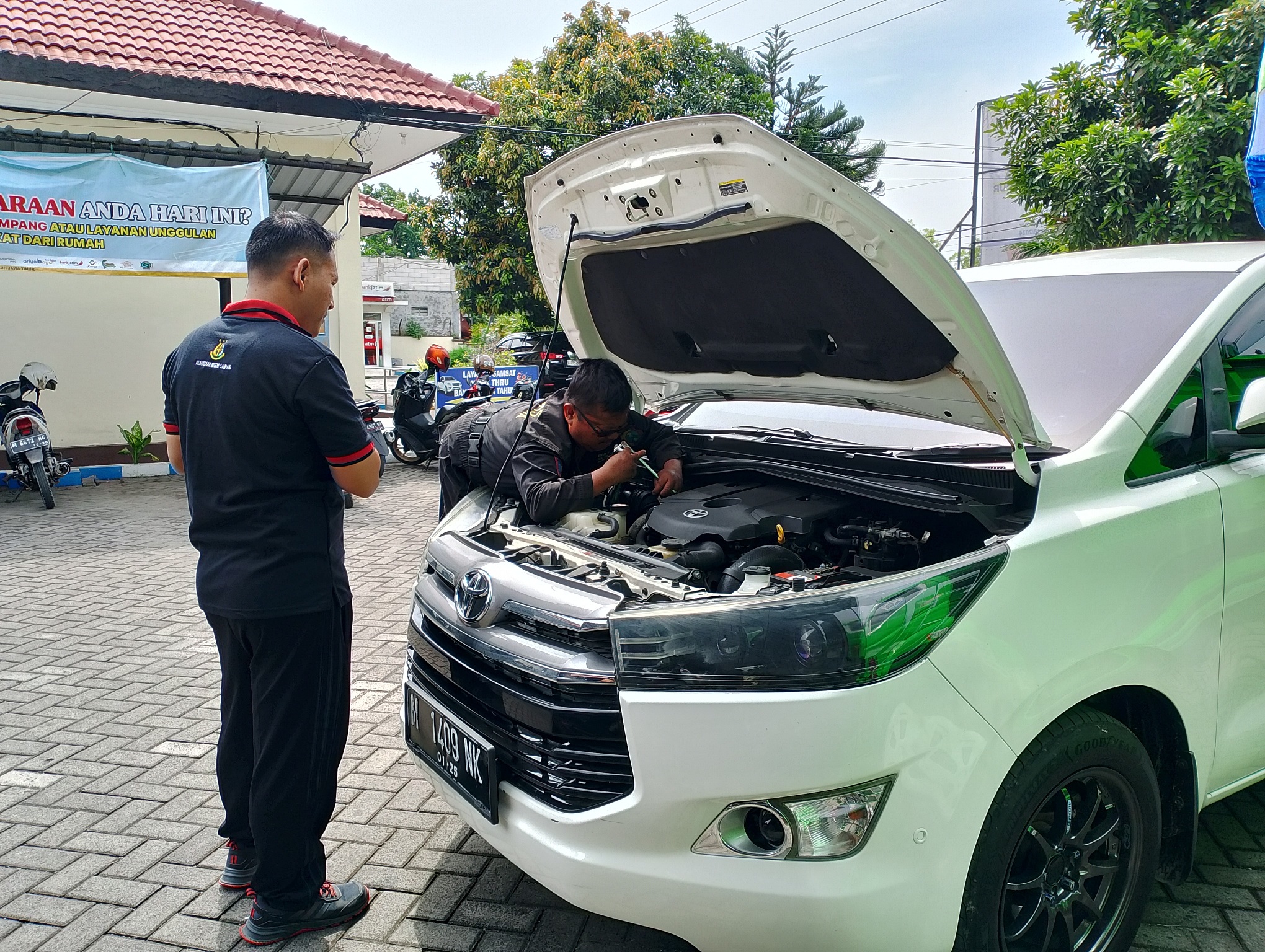 TERTIB: Petugas KB Samsat Sampang sedang melayani cek fisik mobil pelanggan di halaman kantornya kemarin. (UBAIDILLAHIR RA&rsquo;IE/JPRM)