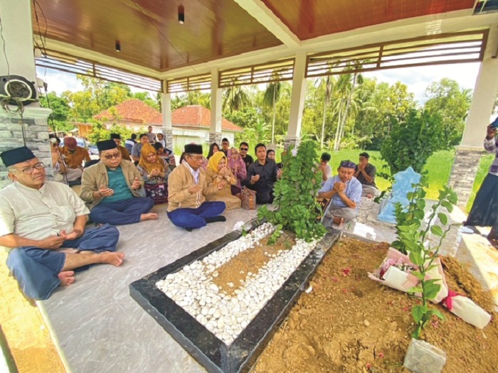 BERDOA: Mahfud MD beserta keluarga ziarah ke makam orang tuanya, alm Mahmodin dan almh Siti Khadijah di TPU Desa Plakpak, Kecamatan Pegantenan, Pamekasan, Minggu (19/1). (AYU LATIFAH/JPRM)