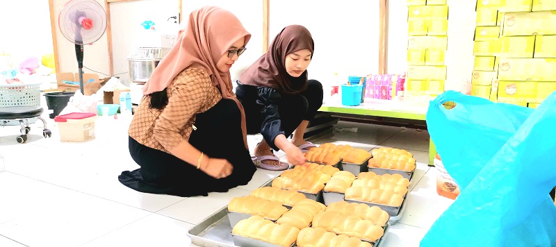 KONTROL PRODUKSI: Pemilik usaha Roti Gembong Menul Ramadani (kiri) membimbing peserta magang di dapur produksi outlet Kalianget, Sumenep, Jumat (17/1). (LUKMAN HAKIM AG/JPRM)
