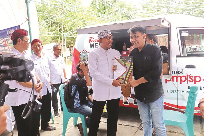 PEDULI: Bupati Sumenep Achmad Fauzi Wongsojudo (dua dari kanan) memberikan dokumen perizinan kepada pelaku usaha melalui mobil keliling pada April 2024. (PROKOPIM SUMENEP UNTUK JPRM)