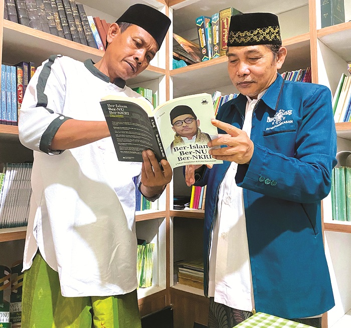 LITERATUR: Wakil Ketua PCNU Pamekasan KH Zainul Hasan (kanan) dan Ketua Panitia Harlah Ke-102 NU PCNU Pamekasan Kiai Ikhsan Ikhwani membaca buku di Kantor PCNU Pamekasan, Jumat (17/1).