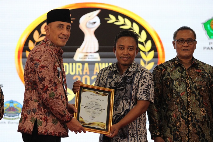 BERPRESTASI: Pj Bupati Bangkalan Arief M. Edie menyerahkan piagam penghargaan kepada Kepala DPRKP Mohammad Hasan Faisol pada Malam Anugerah MA 2024 di Sentra IKM Bangkalan, Jumat, 20 Desember 2024.