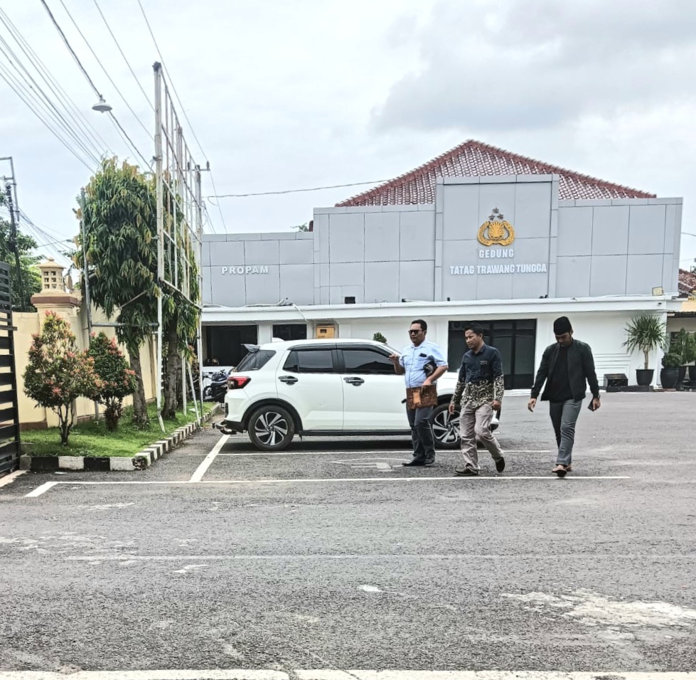 SELESAI DIPERIKSA: Abdullah alias Abe (kanan) berjalan menuju gerbang depan Polres Pamekasan, Rabu (22/1). (ISTIMEWA)
