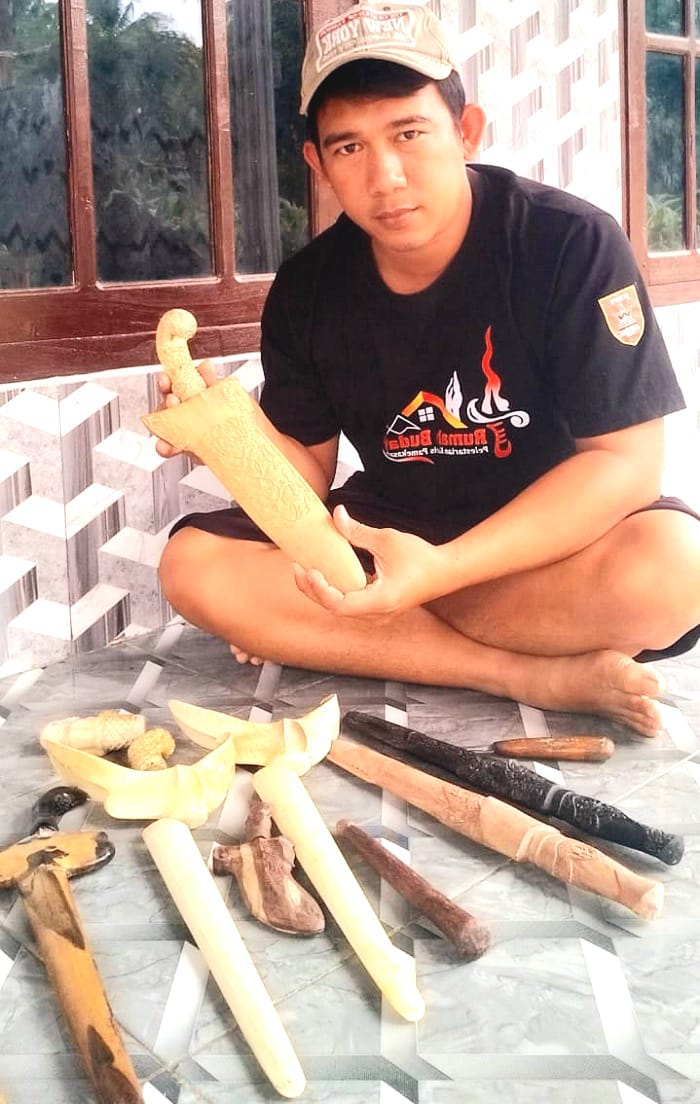 FOKUS: Perajin warangka keris Fikri Zainurrahman menunjukkan hasil karyanya di Desa Palongan, Kecamatan Bluto, Sumenep, Sabtu (18/1). (FIKRI ZAINURRAHMAN UNTUK JPRM)