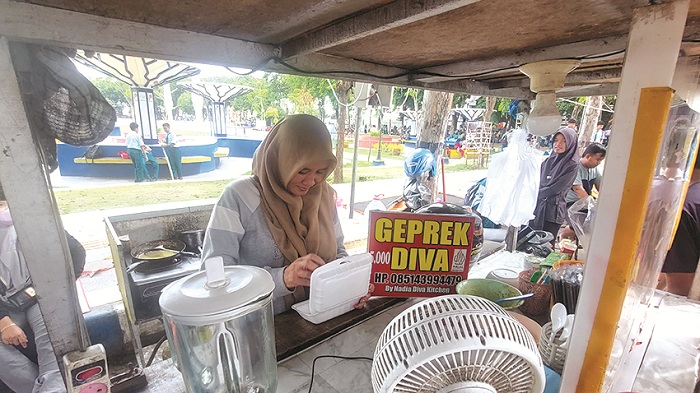LARIS: Owner Geprek Diva Siti Nadia Ulfa menyiapkan produk di lapaknya di Jalan Wijaya Kusuma, Kota Sampang, Rabu (15/1). (JUNAIDI PONDIYANTO/JPRM)