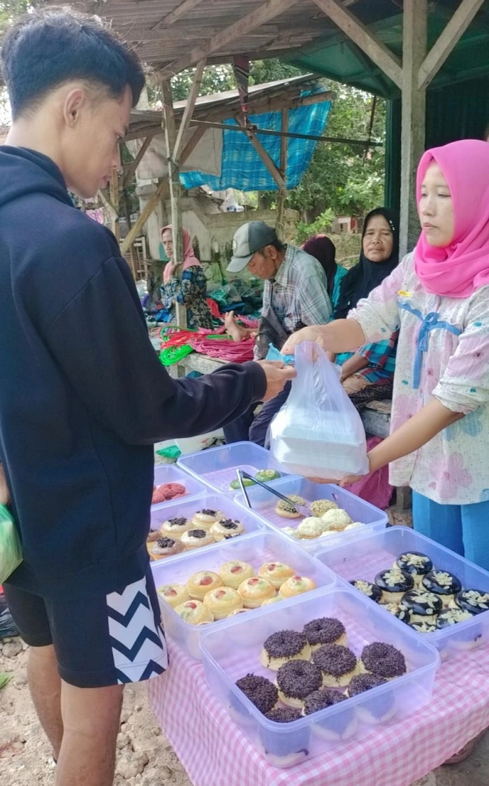 LARIS: Pekerja Yatimatul Bahariah melayani pembeli donat di Desa Tlontoraja, Kecamatan Pasean, Pamekasan, Sabtu (18/1). (SISIL UNTUK JPRM)