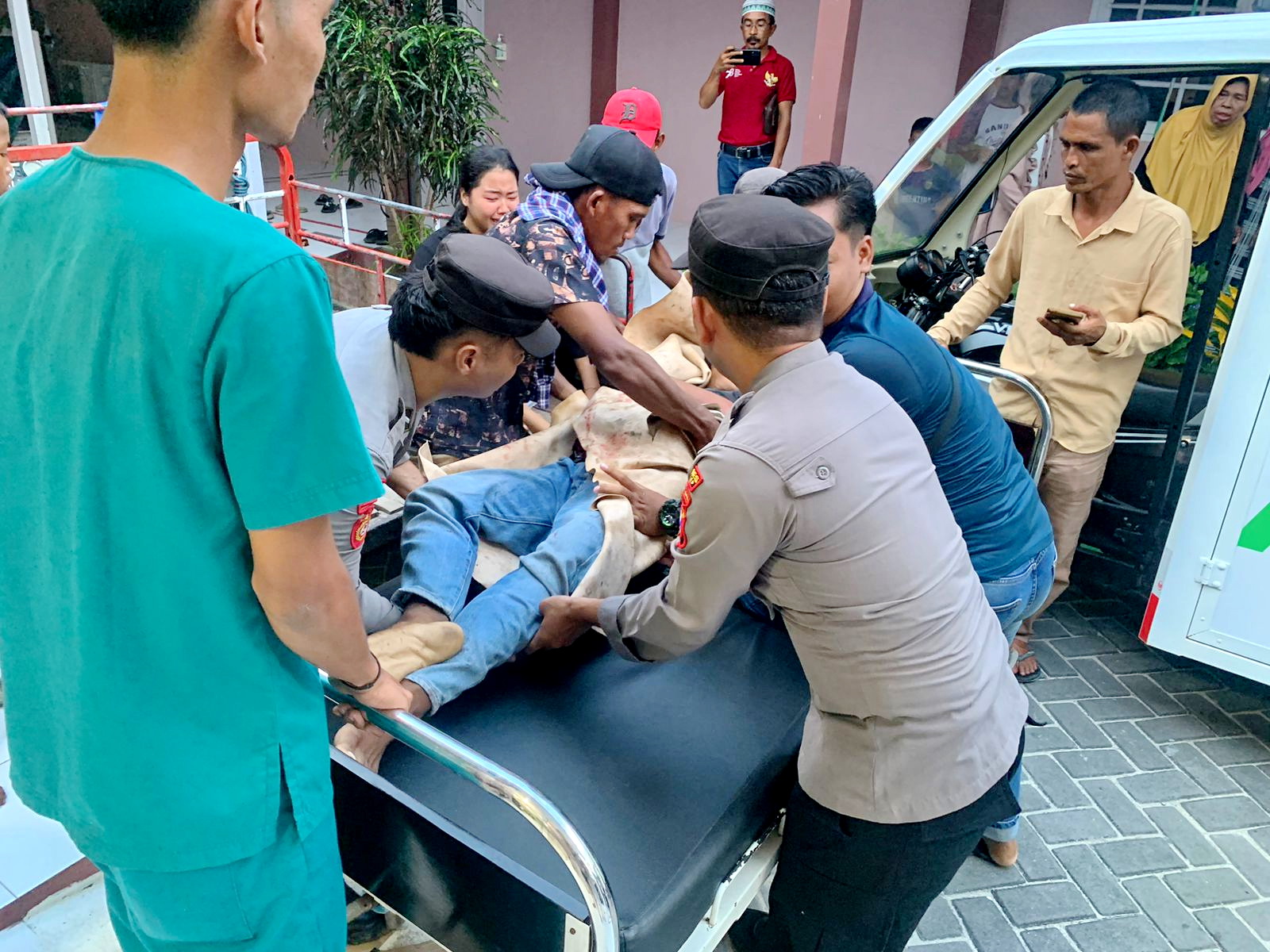 SITA PERHATIAN: Warga menurunkan korban dari mobil ambulans ke ranjang pasien di Puskesmas Sapeken, Sumenep, Rabu (22/1). (POLRES SUMENEP UNTUK JPRM)