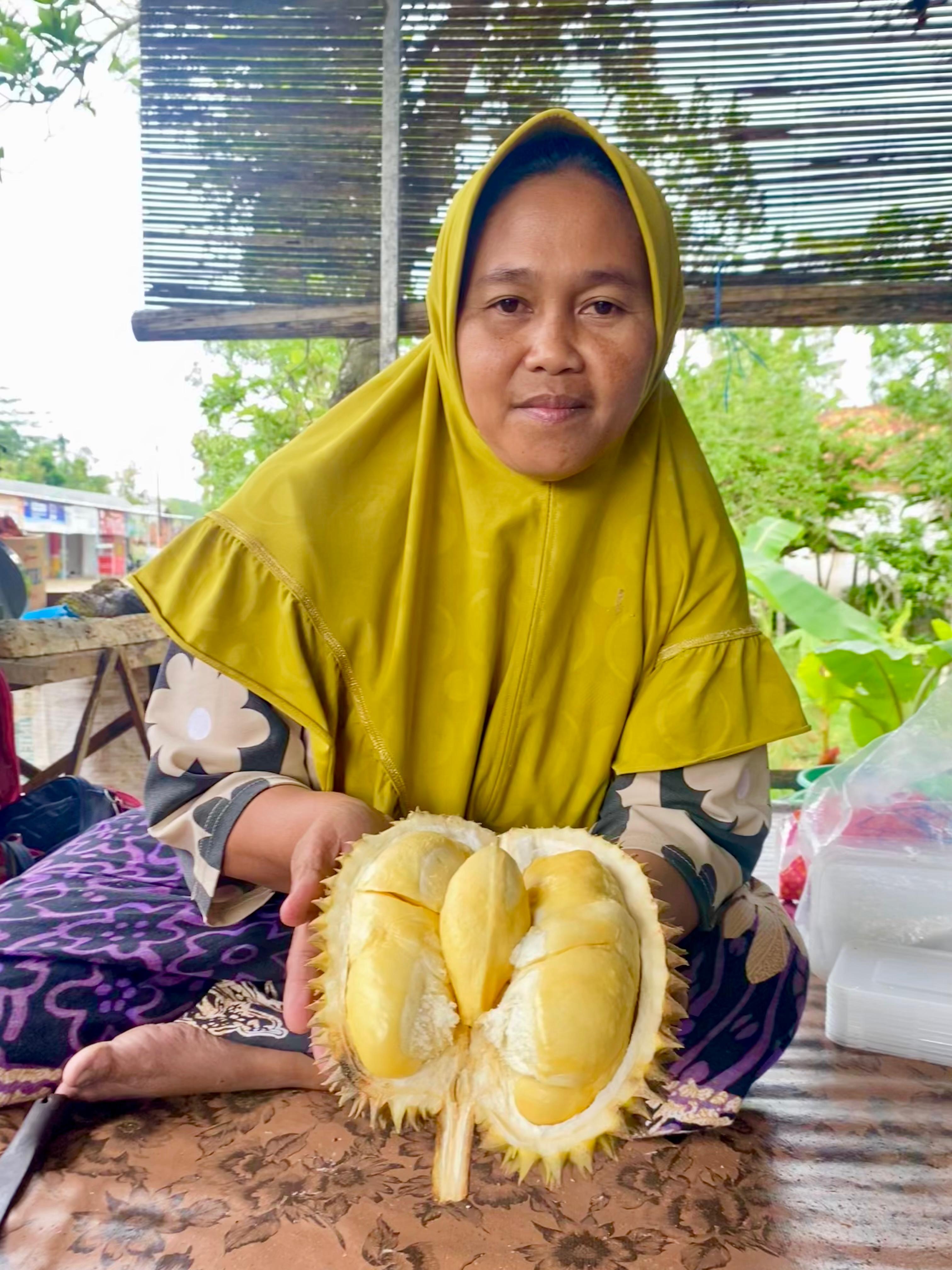 LARIS: Siti Zainab menunjukkan durian mentega yang dijual di lapaknya di Desa Tebul Timur, Kecamatan Pegantenan, Pamekasan, Jumat (24/1). (MOH. IQBAL AFGANI/JPRM)