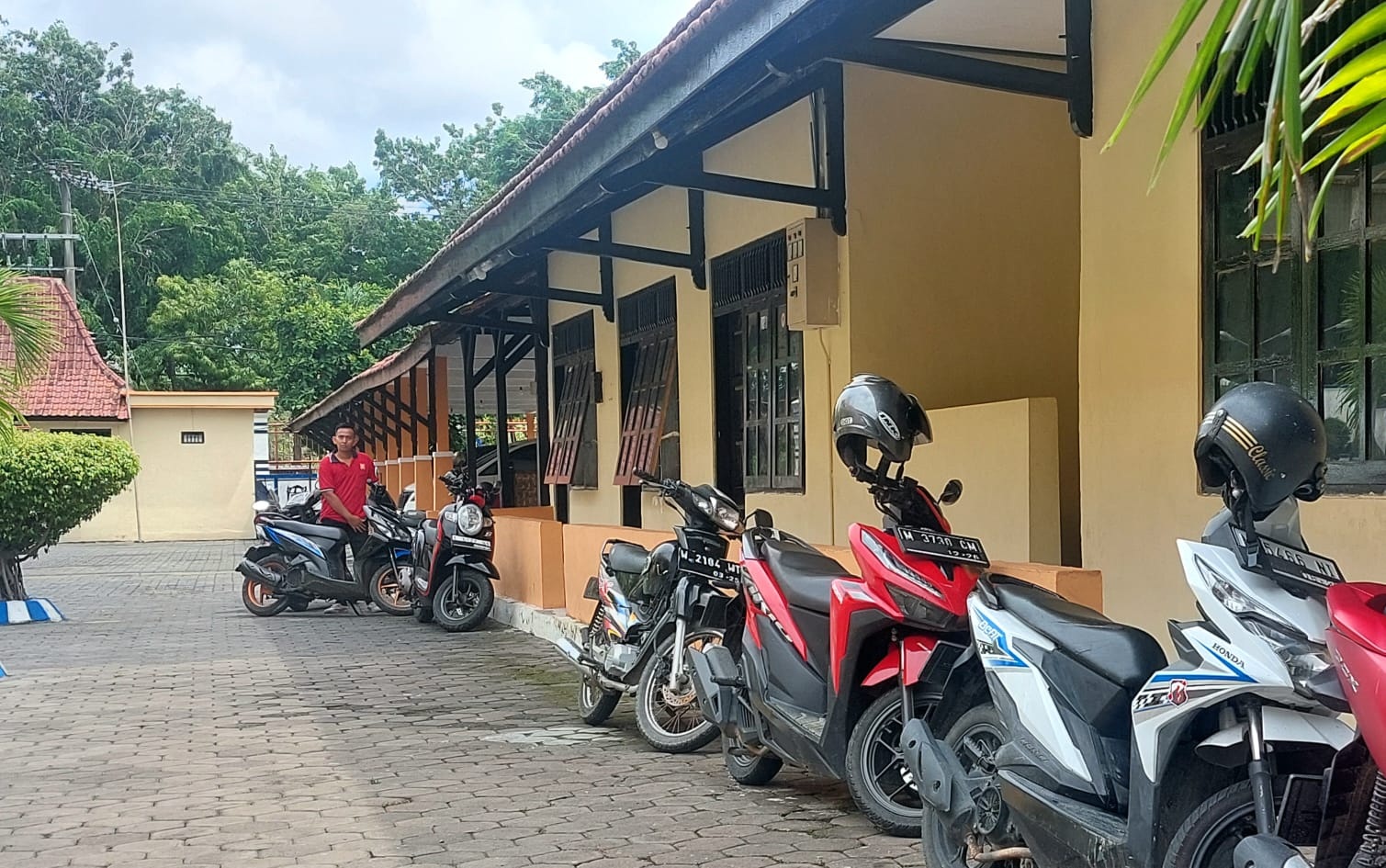 PARKIR BERLANGGANAN: Warga berada di sekitar kendaraan roda dua yang terparkir di halaman kantor DPRD Sampang, Rabu (8/1). (JUNAIDI PONDIYANTO/JPRM)