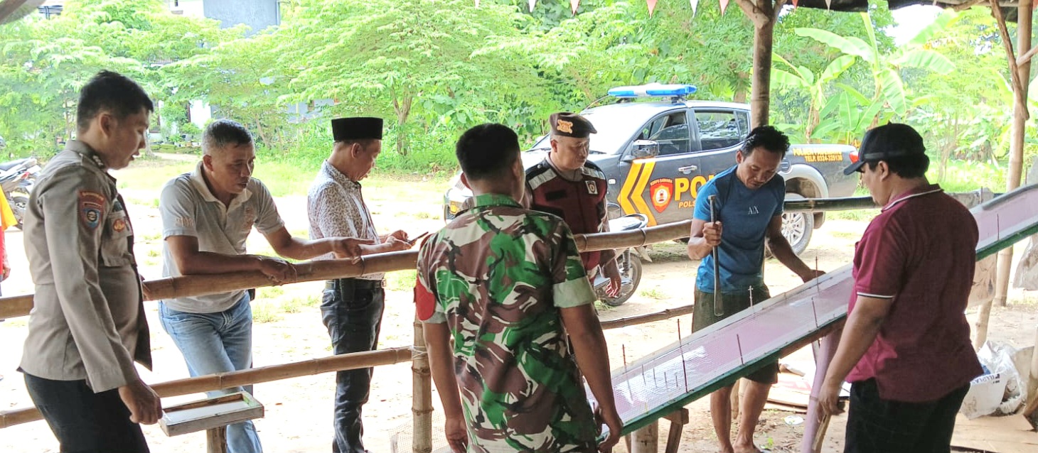 BERSINERGI: Anggota kepolisian bersama prajurit TNI membongkar papan peluncur kelereng di Desa Buddagan, Kecamatan Pademawu, Minggu (26/1). (ISTIMEWA)