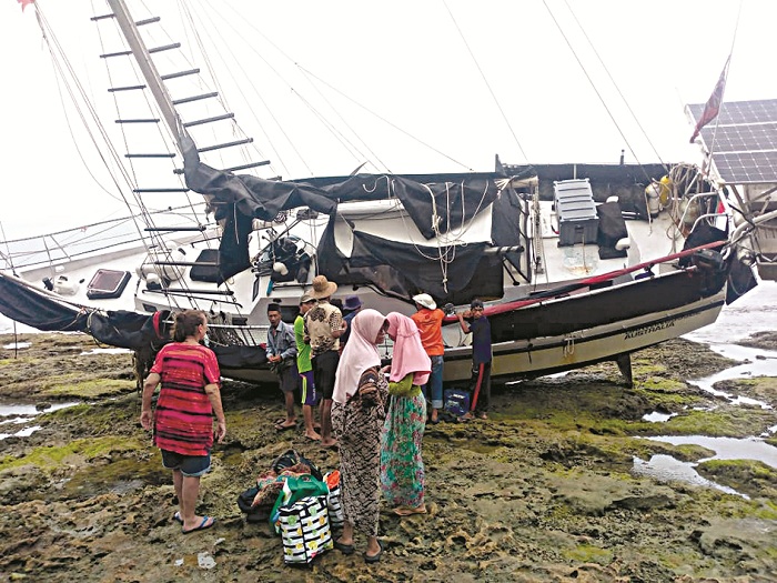 SITA PERHATIAN: Warga melihat kapal warga Australia yang terdampar di perairan Desa Banraas, Pulau Gili Iyang, Kecamatan Dungkek, Sumenep, Kamis (30/1). (EDI UNTUK JPRM)