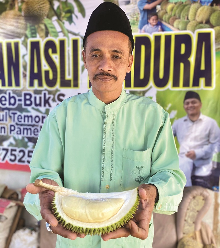 MANIS: Abd. Azis menunjukkan buah durian susu di Desa Tebul Timur, Kecamatan Pegantenan, Pamekasan, Jumat (31/1). (MOH. IQBAL AFGANI/JPRM)