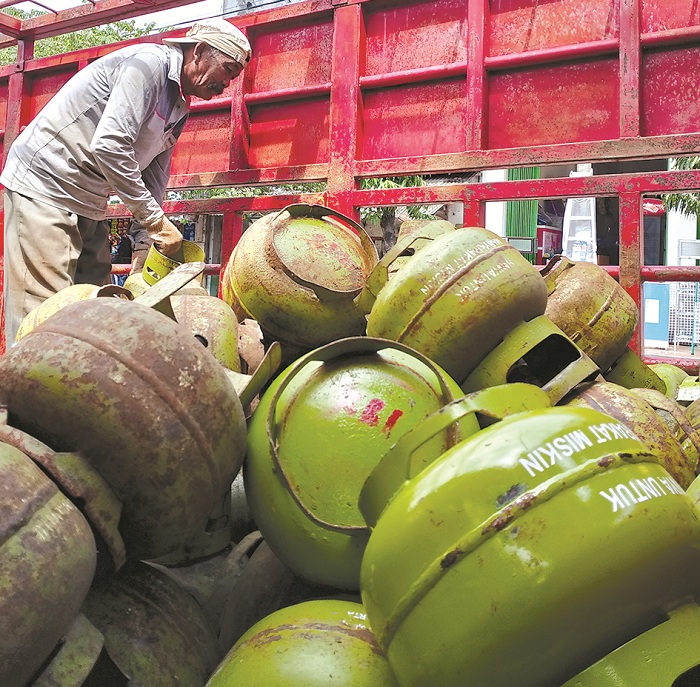 POLEMIK: Karyawan Pangkalan Ali Mas&rsquo;ut menurunkan LPG 3 kg dari truk pengiriman di Jalan Kramat I, Sampang, Selasa (4/2). (UBAIDILLAHIR RAIE/JPRM)