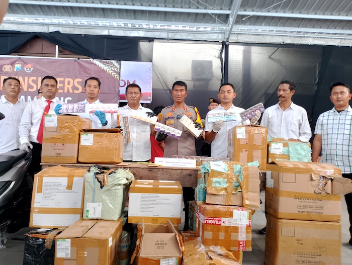 ILEGAL: Kapolres Sampang AKBP Hartono (baju cokelat) menunjukkan barang bukti rokok ilegal yang diamankan anggotanya dari J&T Cargo di Kecamatan Banyuates, Sampang, kemarin. (UBAIDILLAHIR RAIE/JPRM)