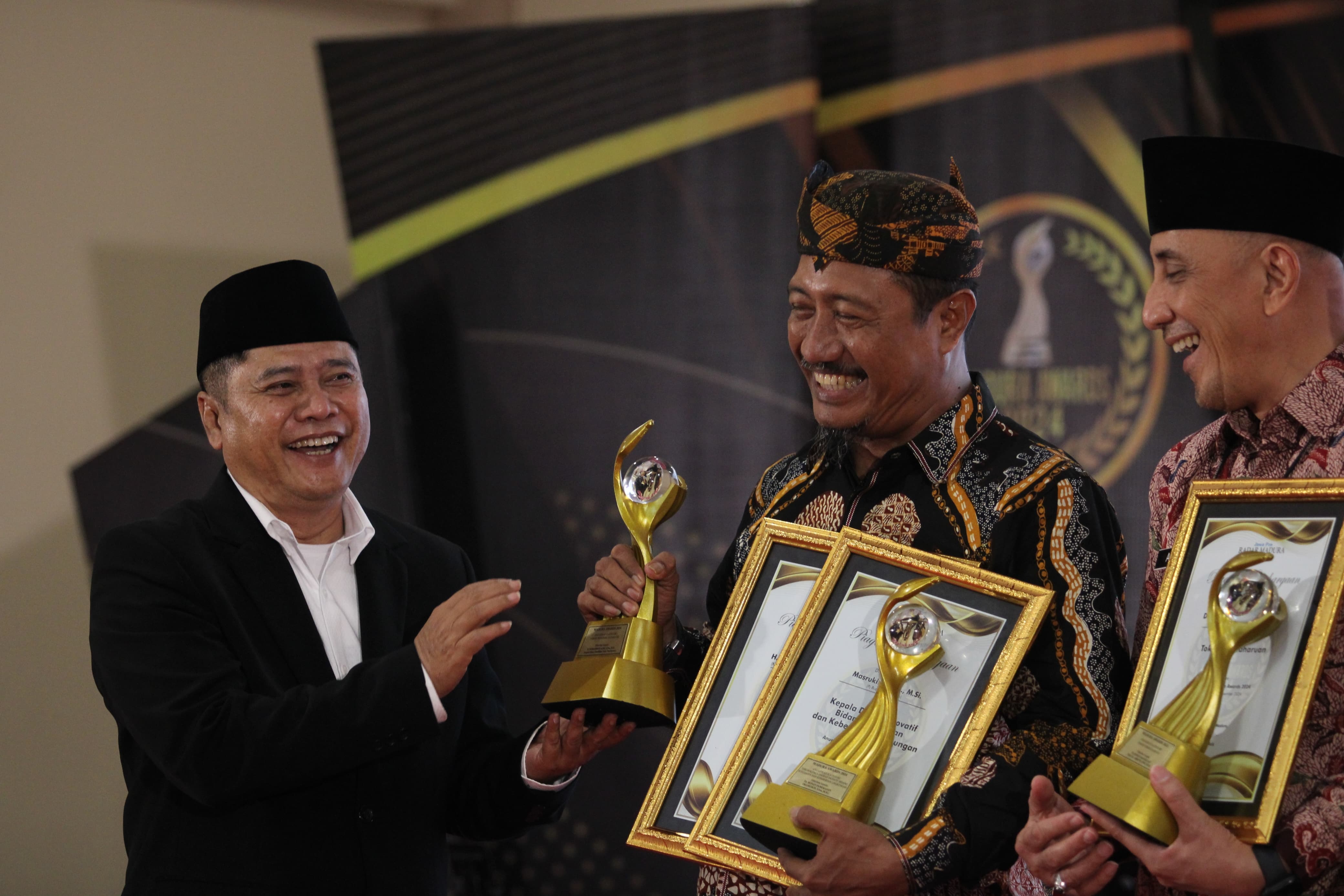 EKSPRESIF: Direktur JPRM Abdul Aziz menyerahkan piagam dan trofi Tokoh Pendidikan Inklusi MA 2024 kepada Kepala Disdikbud Pamekasan Mohamad Alwi di Sentra IKM Bangkalan, 20 Desember 2024. (VIVIN/JPRM)