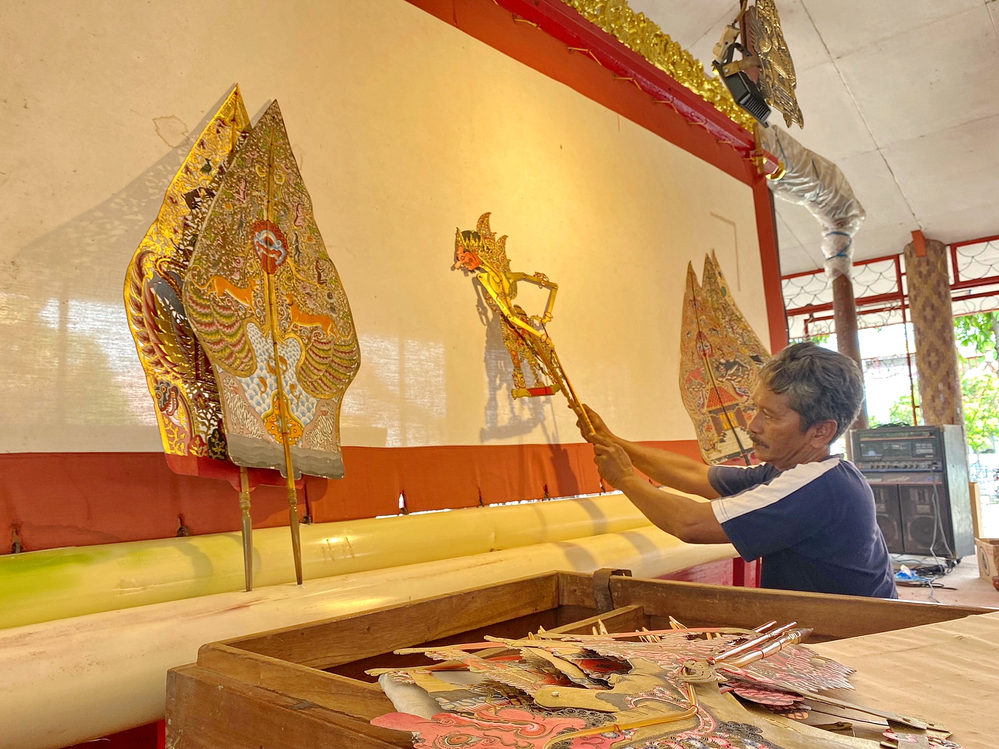 KONSISTEN: Sudirman memainkan wayang di Vihara Avalokitesvara, Desa Polagan, Kecamatan Galis, Sabtu (8/2). (AYU LATIFAH/JPRM)