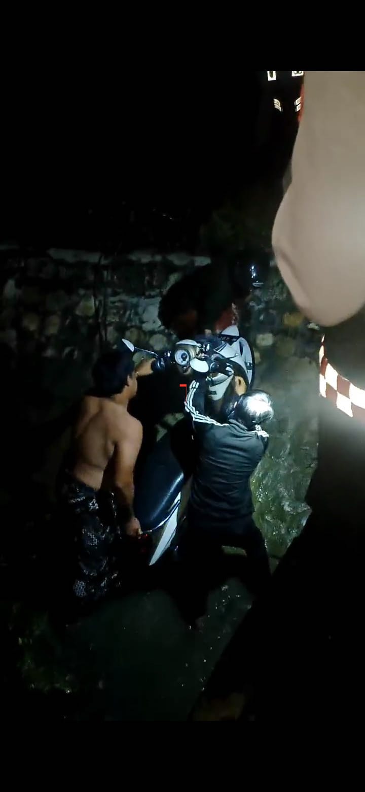 DIEVAKUASI: Warga berupaya menaikkan Honda Scoopy yang tercebur ke parit di Desa Telang, Kecamatan Kamal, Bangkalan. (MUHAMMAD ZAINUL MUSTAQIM UNTUK JPRM)