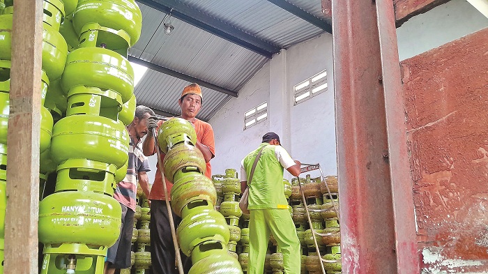 DISUBSIDI: Karyawan mengangkut tabung gas LPG yang dijual agen di Jalan Jokotole, Pamekasan, Senin (3/2). (M. KHOLIL RAMLI/JPRM)