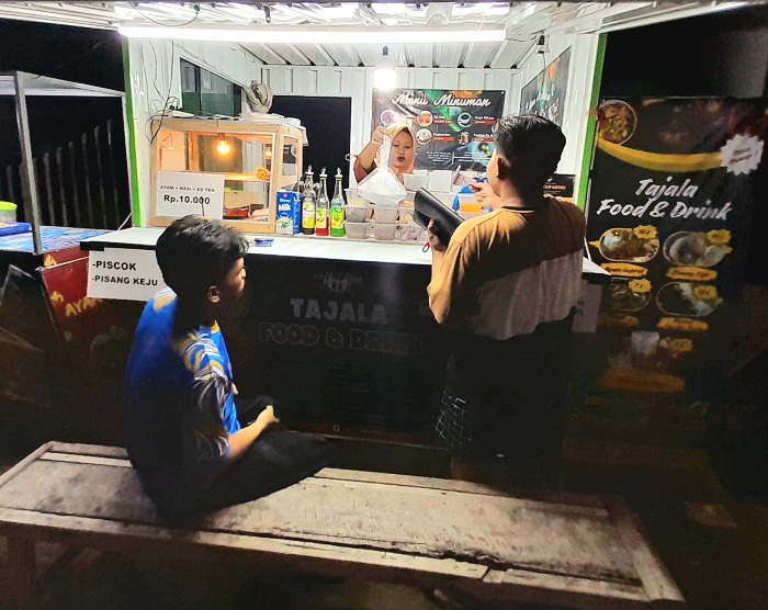 ANTRE: Remaja membeli mamin di Tajala Food & Drink yang berlokasi di Jalan Raya Prenduan, Kecamatan Pragaan, Sumenep, Jumat (31/1) malam. (NAJIBAH AL-ADAWIYAH UNTUK JPRM)