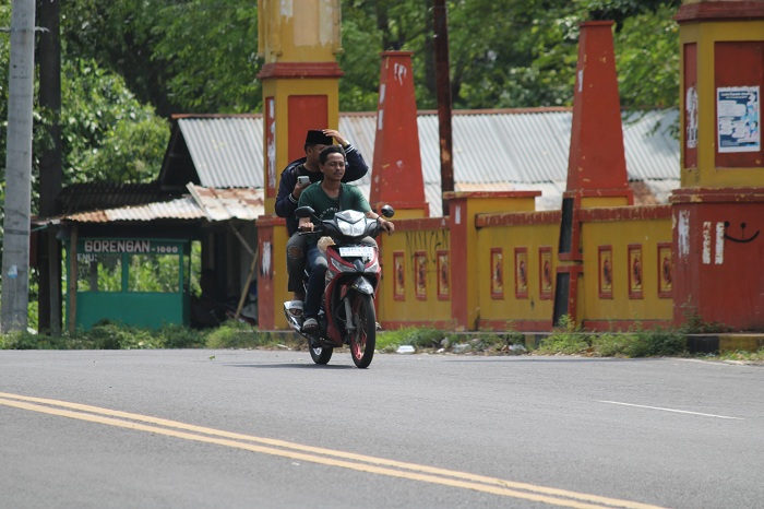 TAK TERTIB: Pengendara sepeda motor tidak mengenakan helm di Jalan Soekarno-Hatta, Kecamatan Socah, Bangkalan, Minggu (9/2). (VIVIN AGUSTIN HARTONO/JPRM)