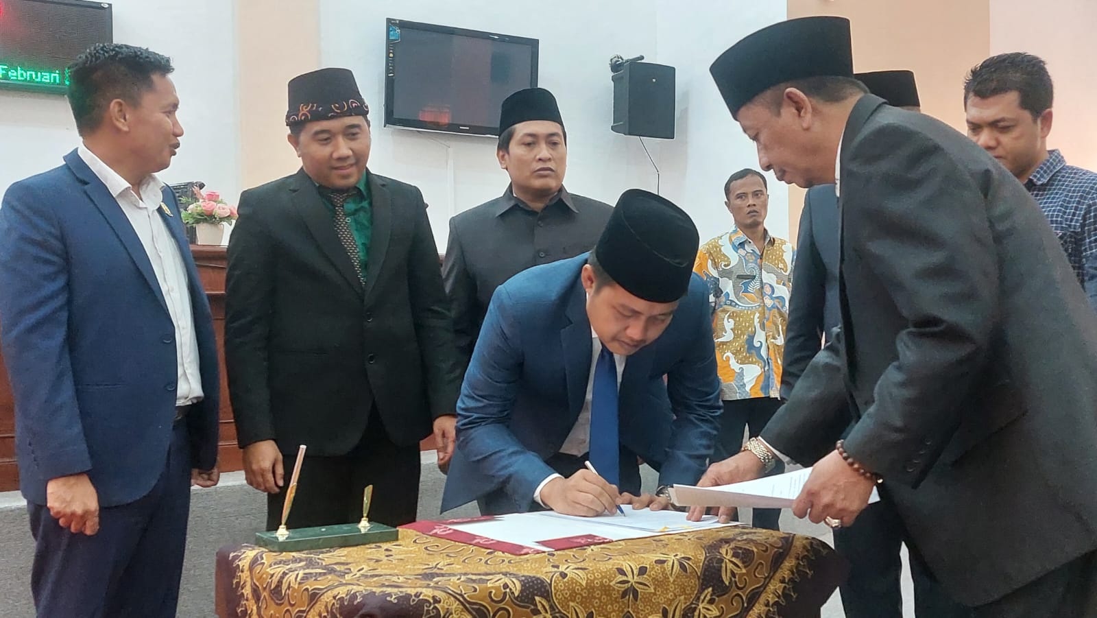 TERTIB ADMINISTRASI: Ketua DPRD Sampang Rudi Kurniawan menandatangani berita acara pengumuman penetapan pasangan calon bupati dan wakil bupati terpilih, Kamis (13/2). (JUNAIDI PONDIYANTO/JPRM)