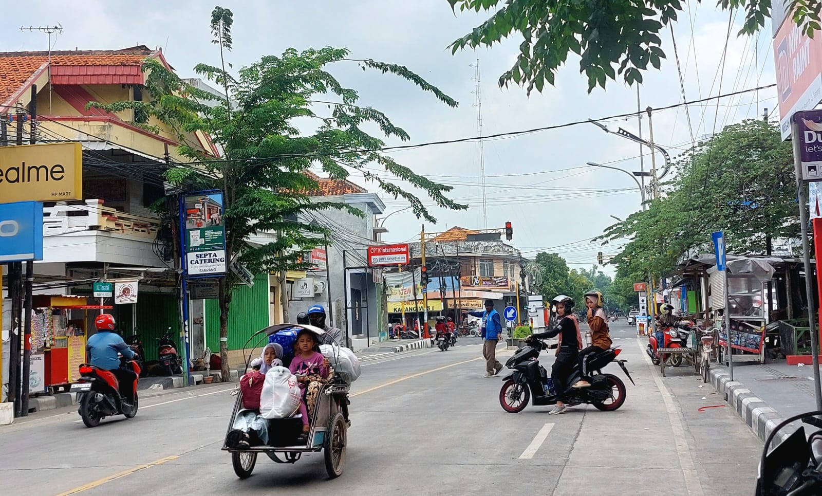 SIBUK: Juru parkir mengenakan rompi mengawal kendaraan di Jalan Trunojoyo, Kota Sampang, Senin (17/2). (JUNAIDI PONDIYANTO/JPRM)