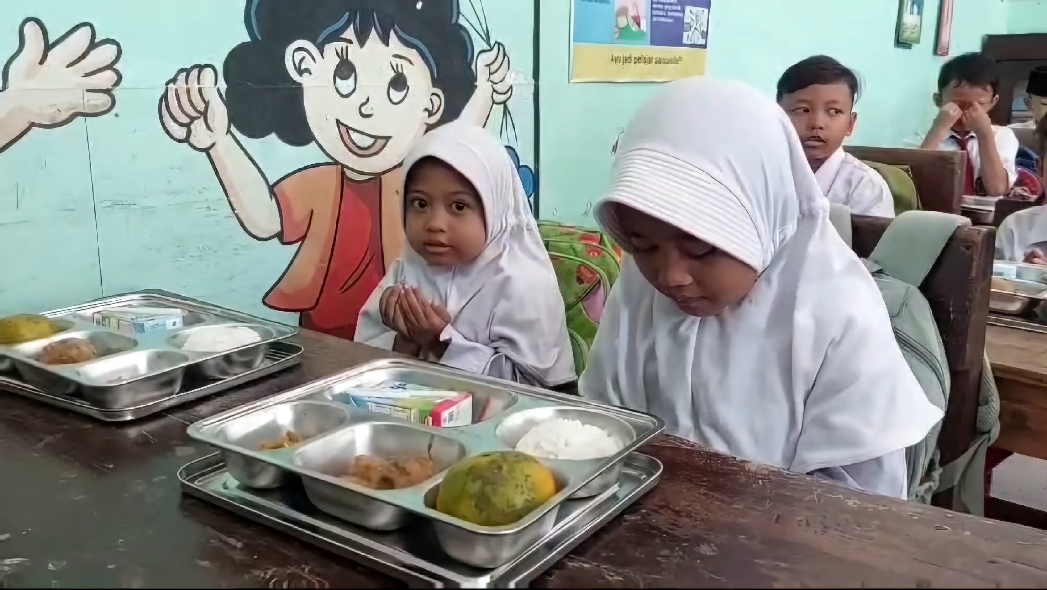 MENIKMATI: Siswa menikmati sajian menu program MBG di SDN Pandian 1, Desa Pandian, Kecamatan Kota Sumenep, Senin (13/1). (MOH. LATIF/JPRM)