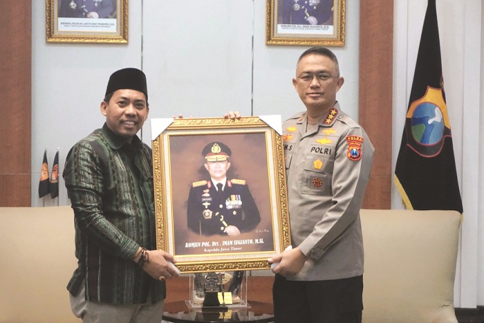 SIMBOLIS: Komisioner KPU Jatim Miftahur Rozaq (kiri) menyerahkan lukisan kepada Astamaops Kapolri Komjen Imam Sugianto di ruang kerjanya Kamis (20/2). (VIVIN AGUSTIN HARTONO/JPRM)