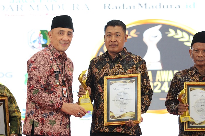 HARUS JADI MOTIVASI: Pj Bupati Bangkalan Arief M. Edie menyerahkan piagam dan trofi MA 2024 kategori SMP terinovatif.