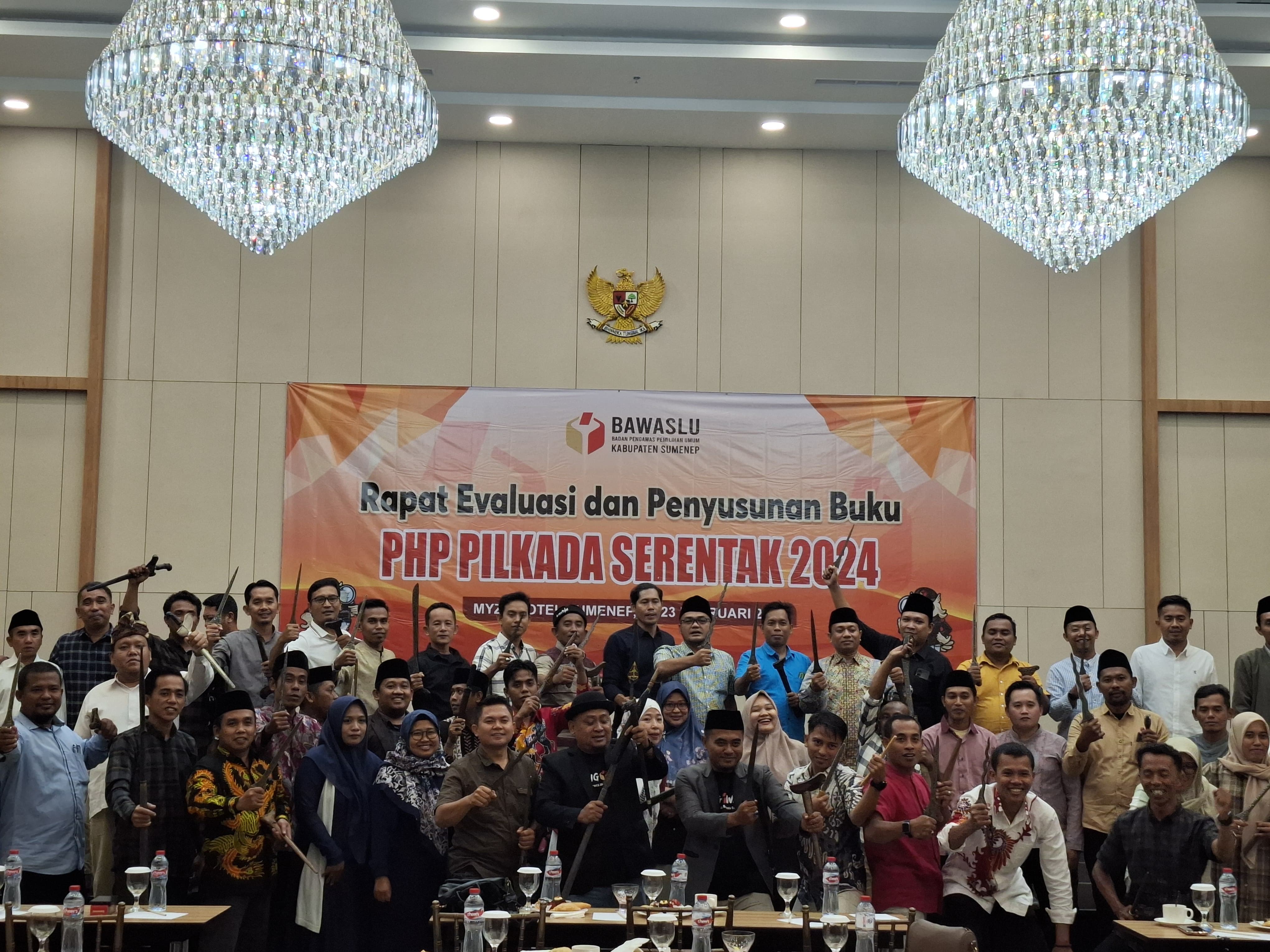 KOMPAK: Komisioner Bawaslu Sumenep bersama Panwascam berfoto bersama sambil memegang keris di Hotel Myze Sumenep, Jumat (21/2).