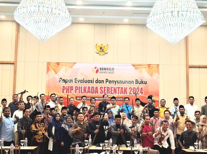 KOMPAK: Anggota Bawaslu Sumenep Moh. Rusydi Zain ZA dan Muarep berfoto bersama panwascam sambil memegang keris di Hotel Myze Sumenep, Jumat (21/2). (MOH. LATIF/JPRM)