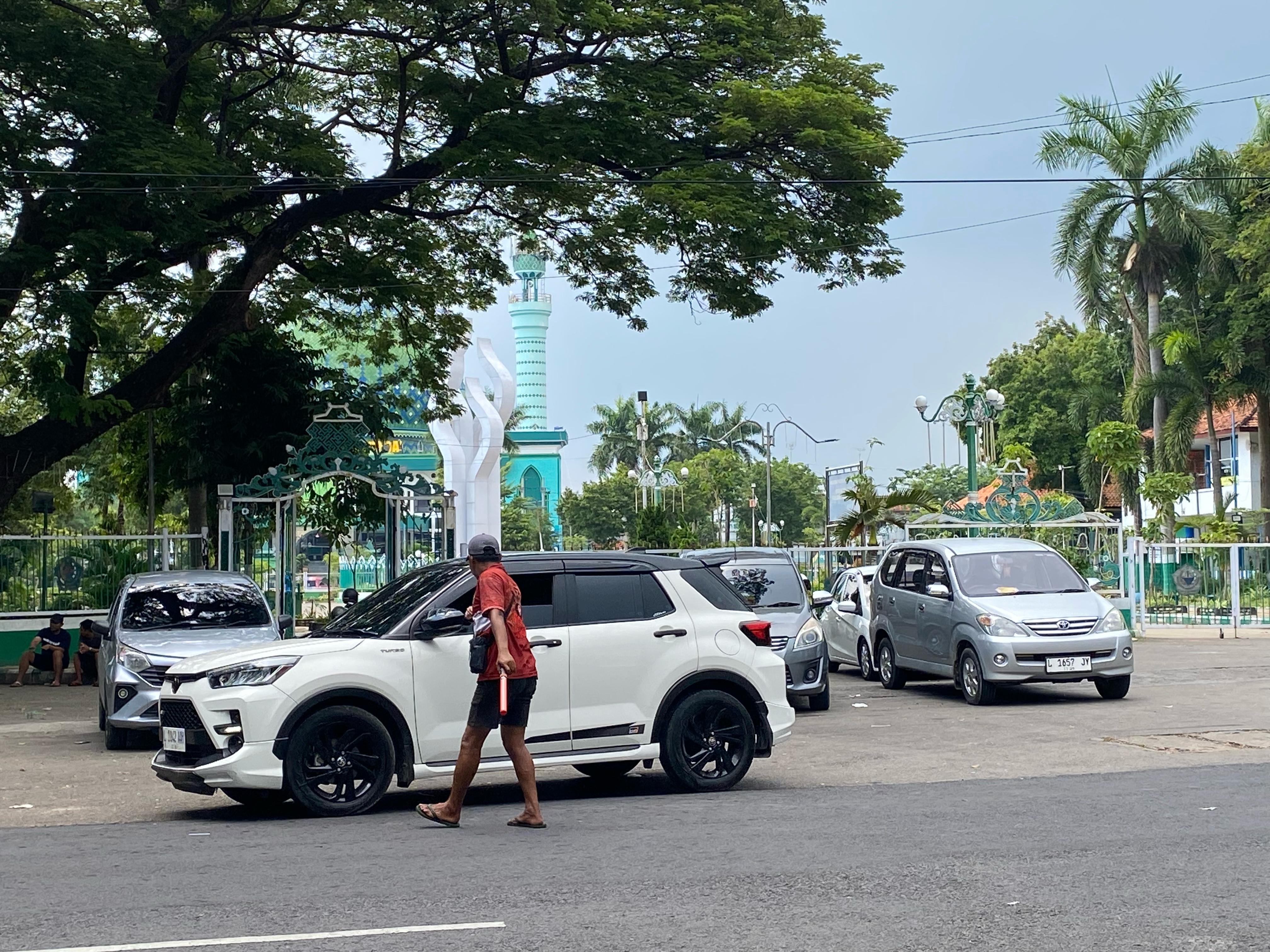 LIAR: Seorang jukir menarik retribusi di area Monumen Arek Lancor, Minggu &nbsp;(16/2). (AYU LATIFAH/JPRM)
