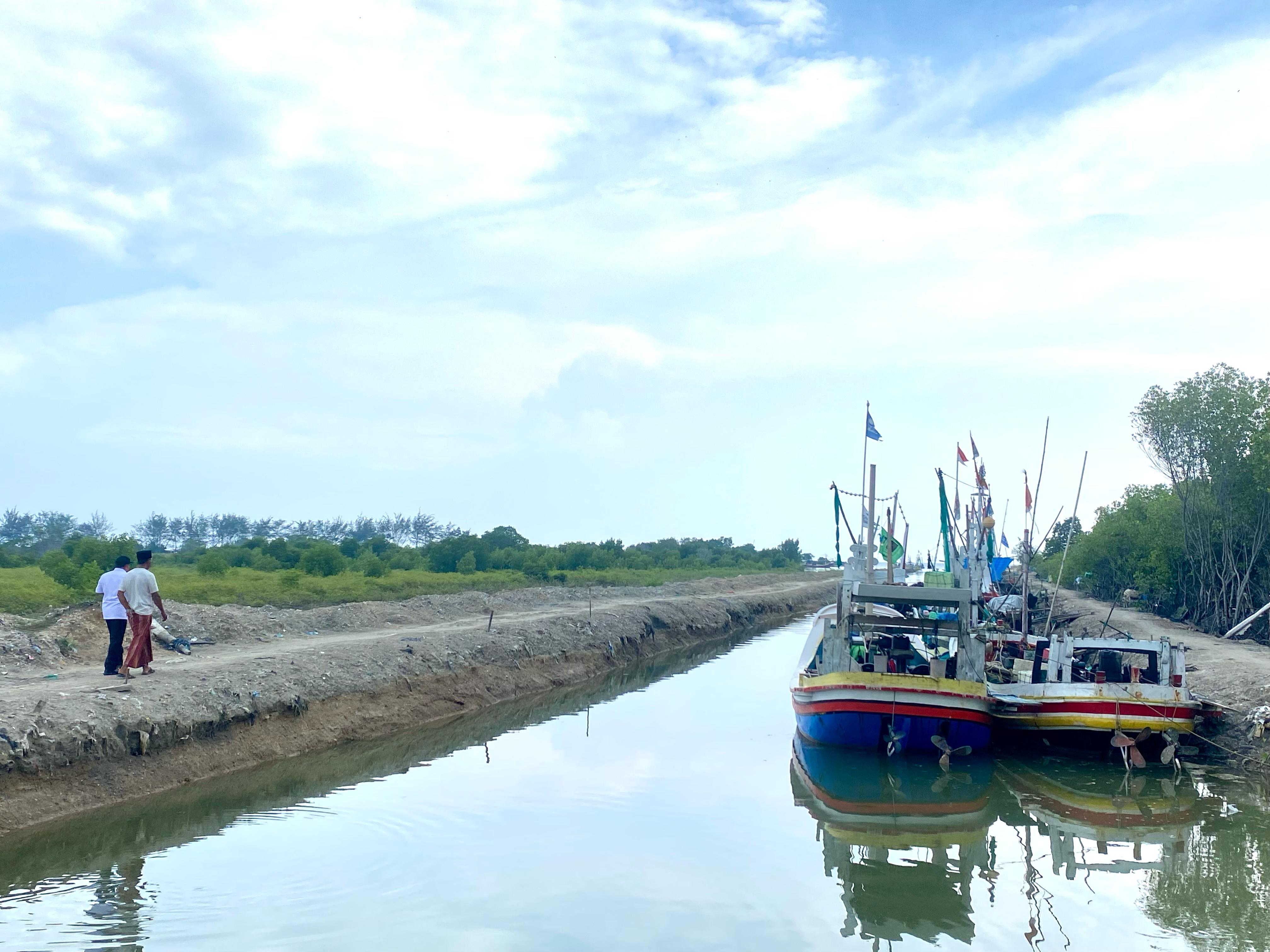 SANTAI: Warga melintas di dekat sungai di Desa Tanjung, Kecamatan Pademawu, Rabu (19/2). (MOH. IQBAL AFGANI/JPRM)