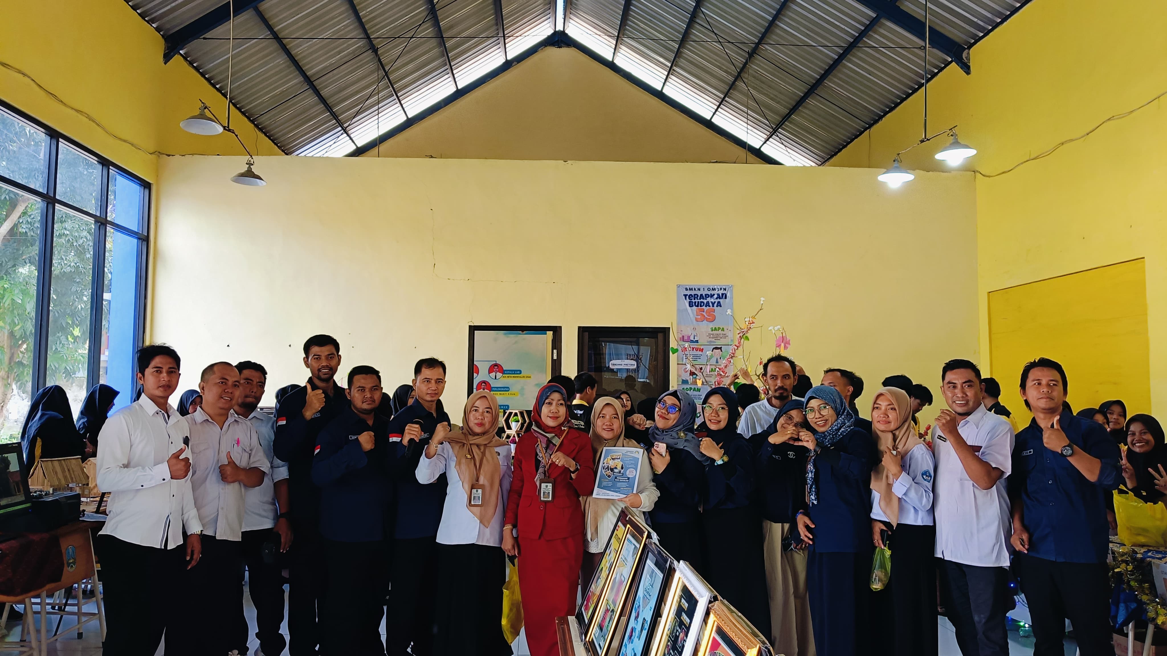KOMPAK: Kepala SMKN 1 Omben Imamatul Jamaliyah (baju merah) berfoto bersama semua guru SMKN 1 Omben pada kegiatan pameran di halaman sekolah, Rabu (26/2).