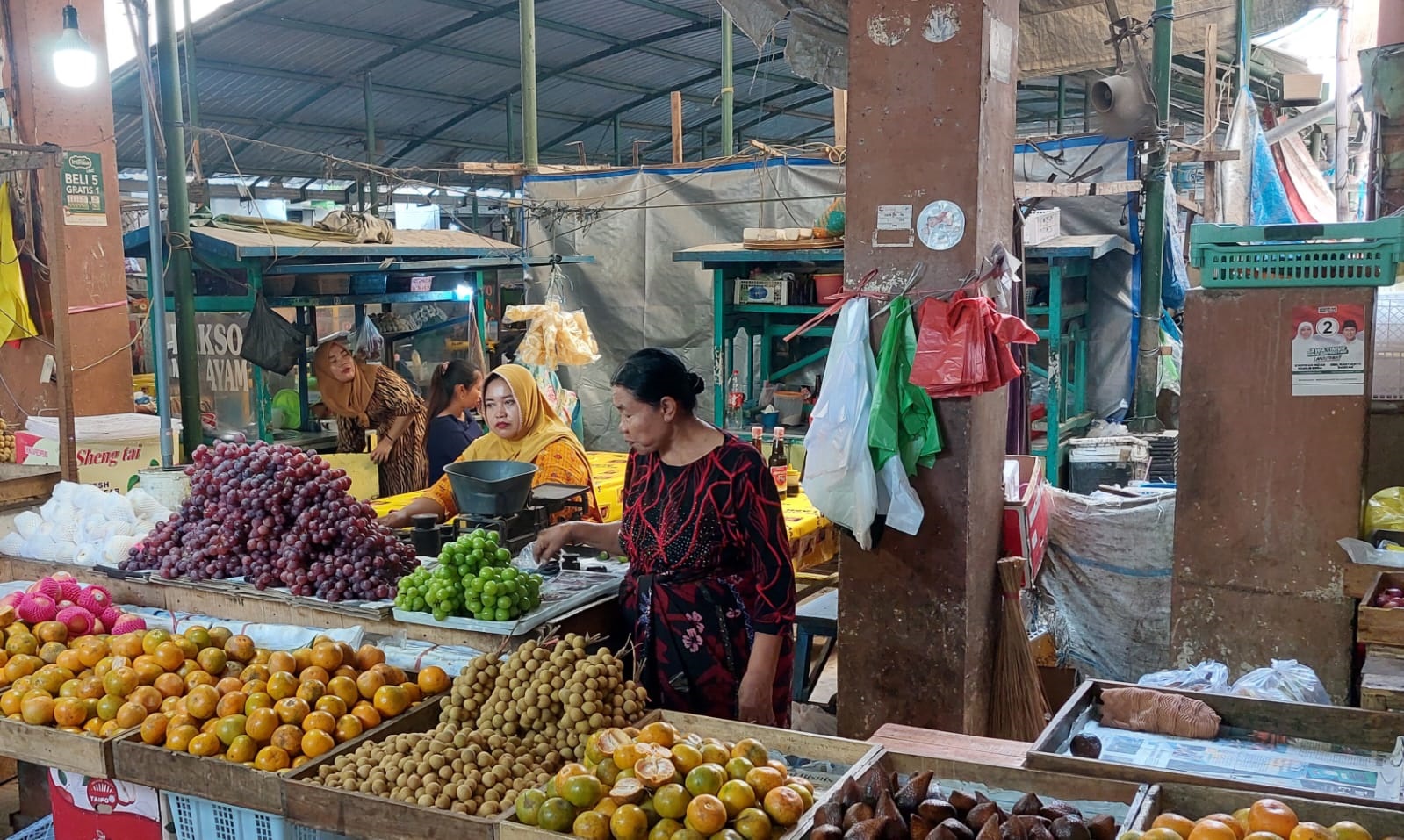 PENGADAAN KARCIS: Pedagang buah sedang berjualan di Pasar Srimangunan, Kecamatan Kota Sampang, Kamis (23/1). (JUNAIDI PONDIYANTO/JPRM)