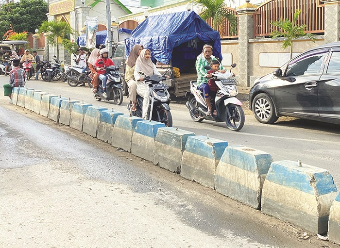 HATI-HATI: Warga melintasi median jalan di Pasar Waru Minggu (23/2). (MOH. IQBAL AFGANI/JPRM)